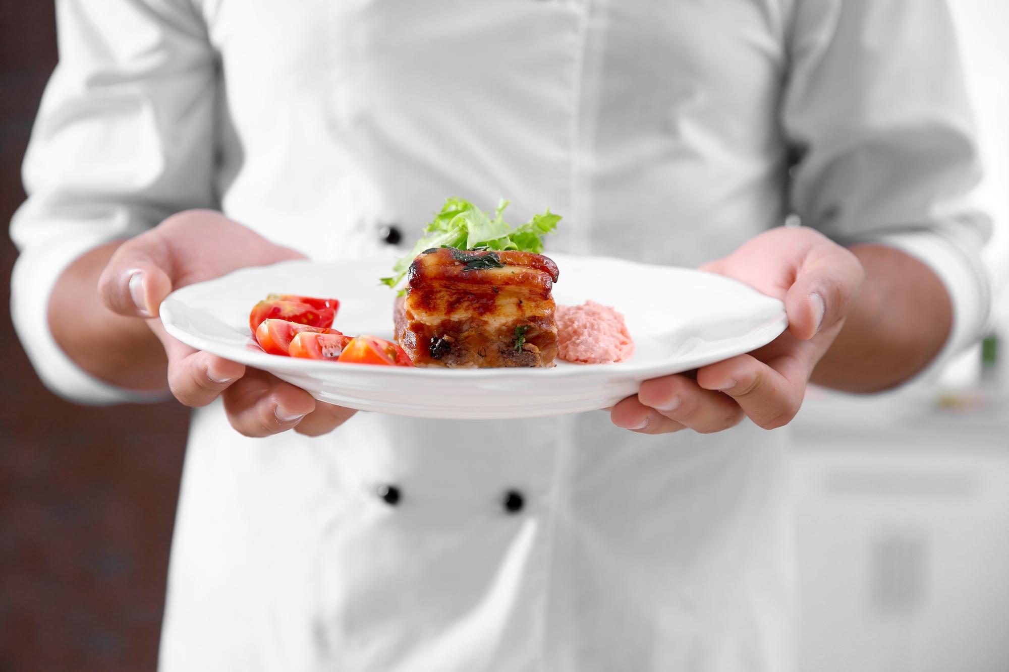 Chef preparing plated dish in warm kitchen